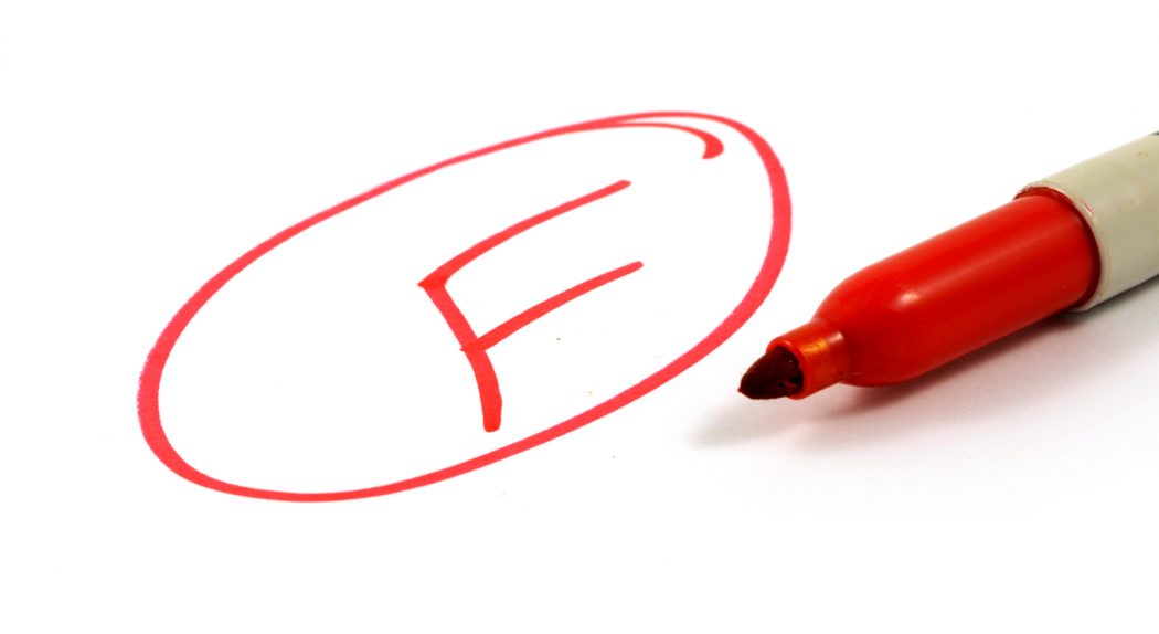 En röd penna och betyget "F" skrivet i en cirkel.